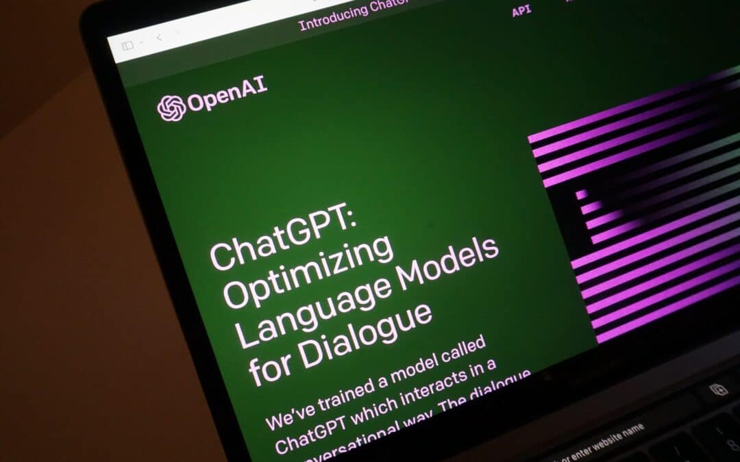 A computer screen displays the OpenAI, ChatGPT homepage.